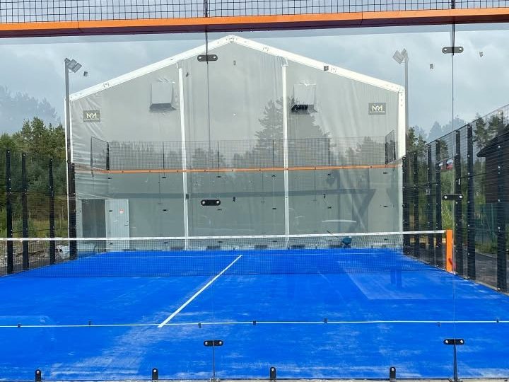 Padelbanen på Evjemoen, med glassvegger og blått banedekke